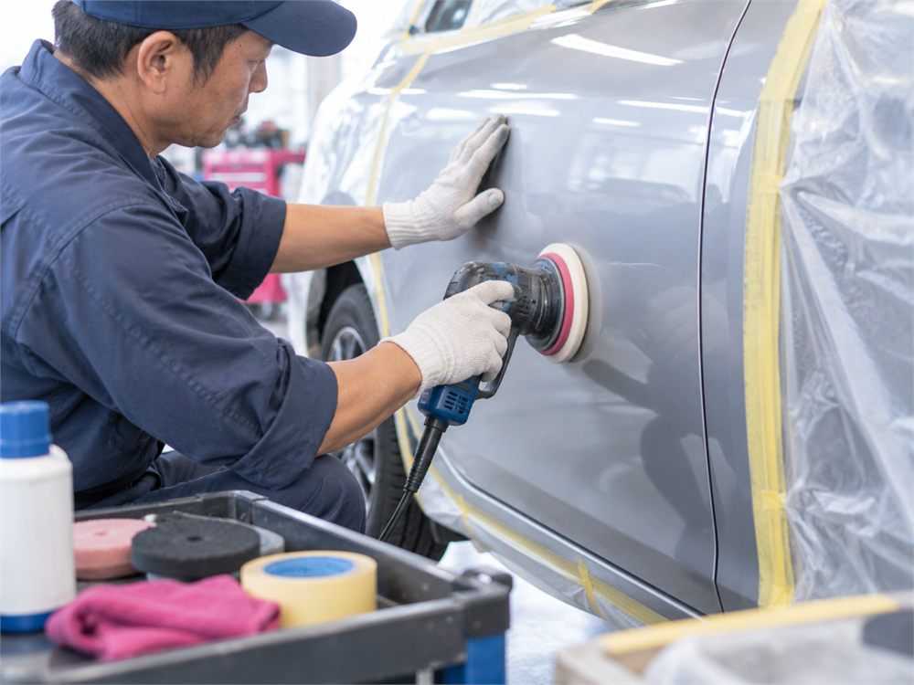 車のドアパネルの外側を処理する整備士